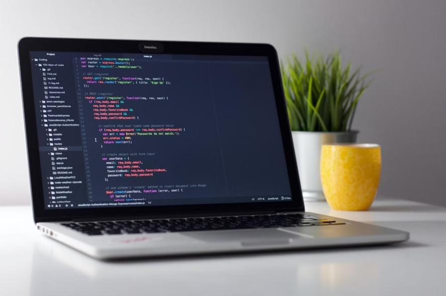 An open laptop with a screen displaying coding language.