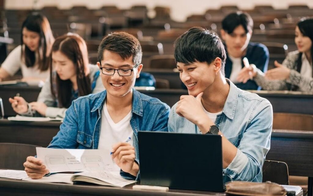Two students review an assignment in a lecture hall.