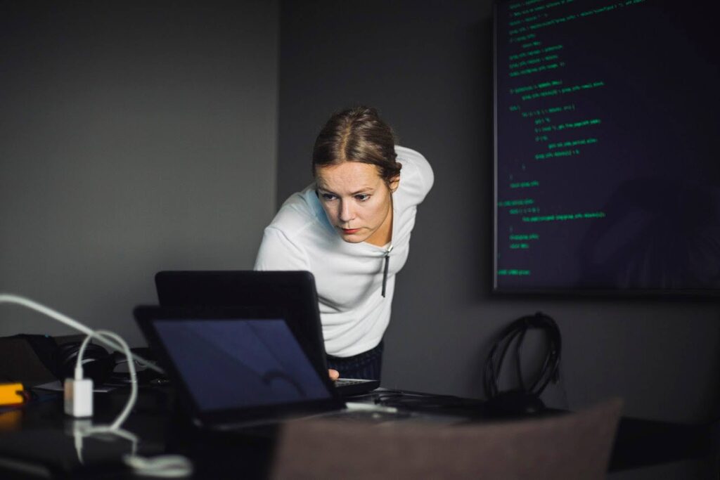 Computer professional working at a laptop in a creative office.