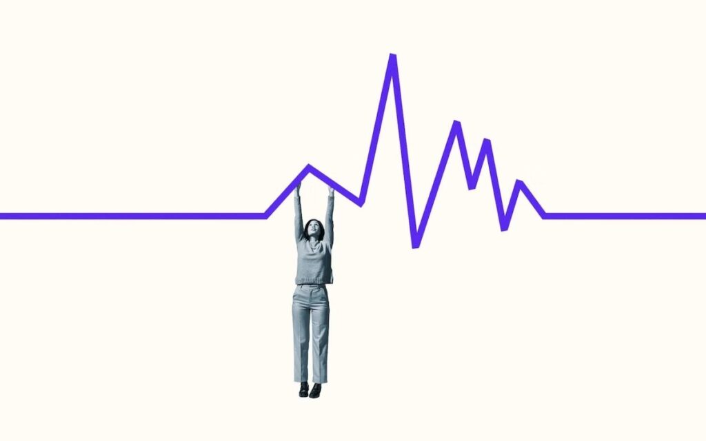 A person dangles from a purple line graph.