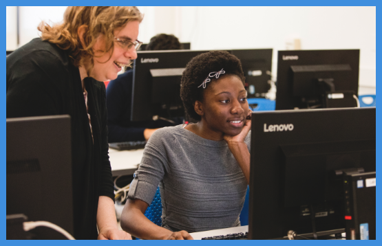 An instructor looking at a computer monitor with a student.