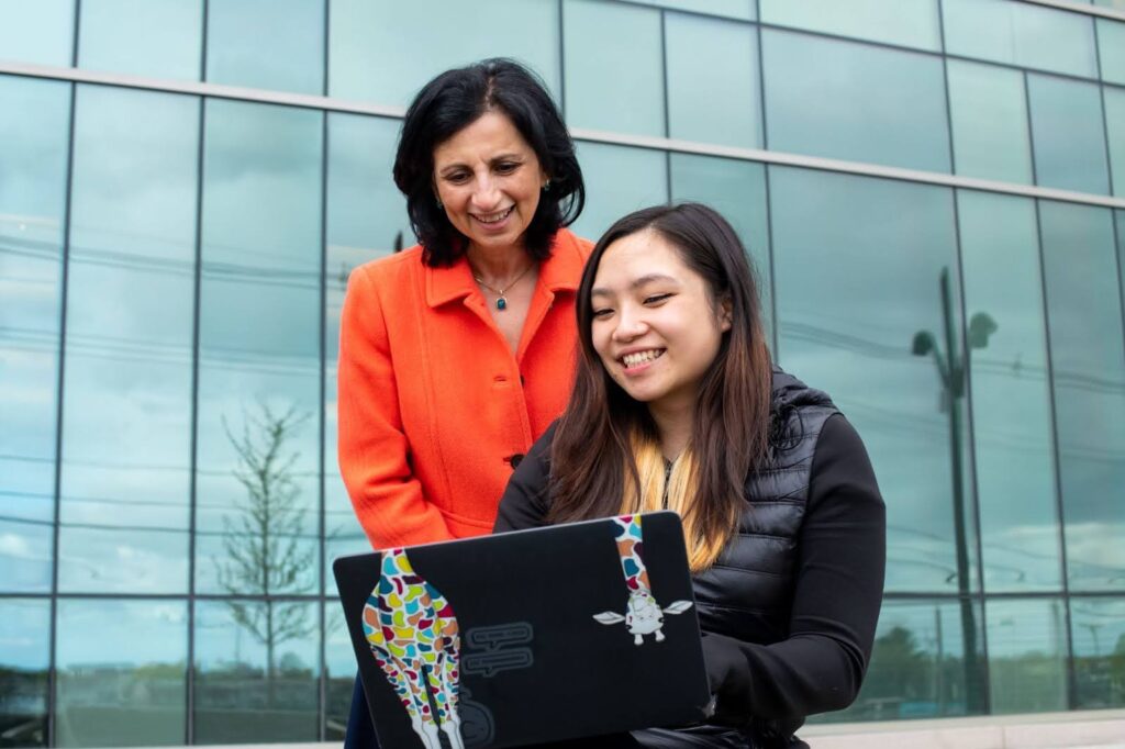 Soha Hassoun, Professor of Computer Science, watches as a student works at a laptop.