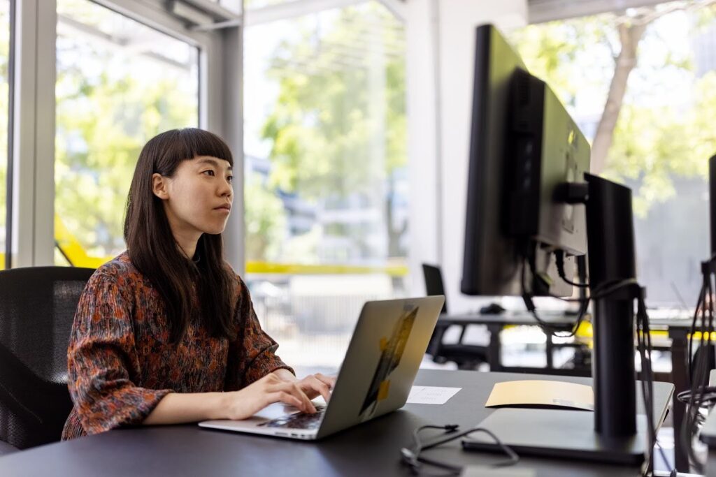 A data scientist works at a multiscreen work station.