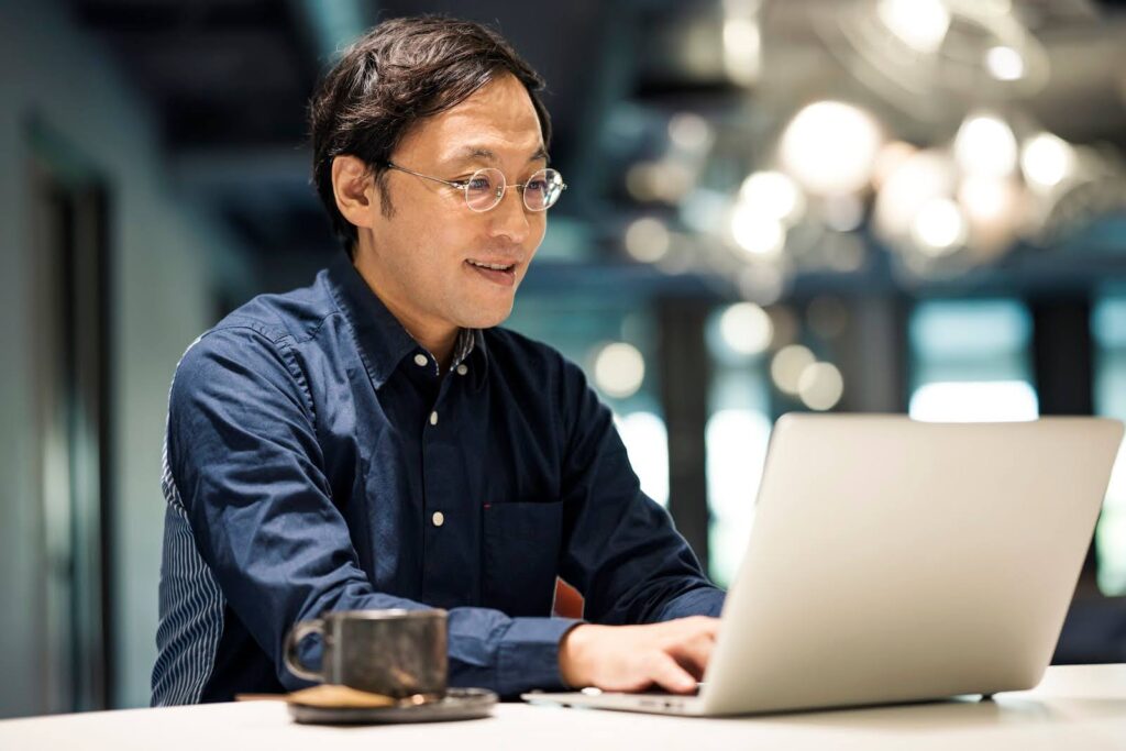 A man types at a laptop computer.